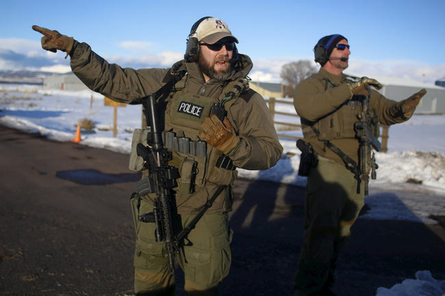 FBI agents talk as they man the entry to the Burns Municipal Airport in Burns, Oregon January 30, 2016.  REUTERS/Jim Urquhart
