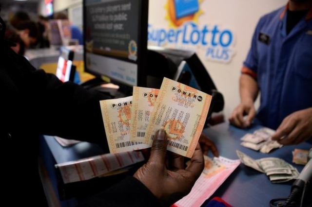 A customer shows their tickets for the Powerball lottery at the California lotto store in San Bernardino County, California, on the California-Nevada state line, Jan. 9, 2016. (Gene Blevins/Reuters)