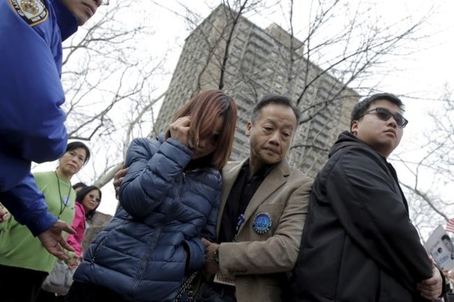 The mother of former NYPD officer Peter Liang, Fenny Liang, is aided as she attends a rally in support of her son in the Brooklyn borough of New York February 20, 2016. REUTERS/Brendan McDermid
