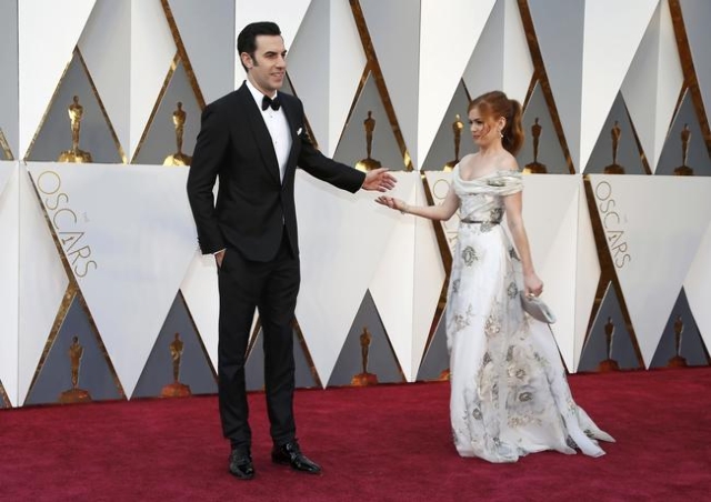 Presenter Sacha Baron Cohen and wife Isla Fisher arrive at the 88th Academy Awards in Hollywood, California February 28, 2016.  REUTERS/Lucy Nicholson