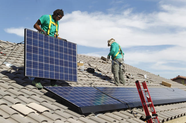 Solar City installation crew leader Greg Kates, left, and Guillermo Aviles install solar panels on a North Las Vegas home Thursday, Oct. 30, 2014. (Las Vegas Review-Journal)