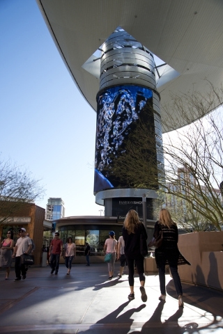 Visitors walk toward one of the massive screens recently added to the pillars underneath the &quot;Cloud,&quot; a steel canopy at the Fashion Show Mall on the Las Vegas Strip on Thursday,  ...