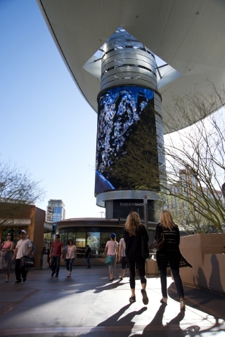Visitors walk toward one of the massive screens recently added to the pillars underneath the "Cloud," a steel canopy at the Fashion Show Mall on the Las Vegas Strip on Thursday, ...