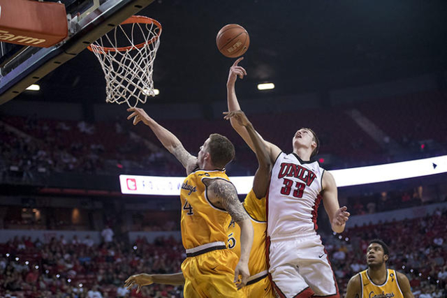UNLV forward Stephen Zimmerman Jr. (33) and Wyoming guard Josh Adams (14) fight for the ball during the first half at the Thomas & Mack Center in Las Vegas on Saturday, Feb. 27, 2016. Joshua D ...