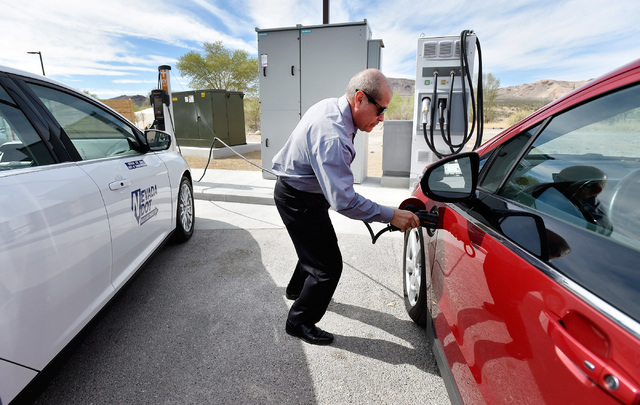 Rudy Garcia plugs-in an all-electric vehicle at the dedication of the first electric car charging station along U.S. Highway 95 Tuesday, March 1, 2016, in Beatty. The station is the fist of many p ...