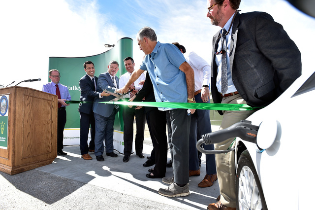 Nevada Gov. Brian Sandoval, center, with other dignitaries cut a ribbon to dedicate the first electric car charging station along U.S. Highway 95 Tuesday, March 1, 2016, in Beatty. The station is  ...
