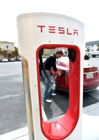 Wild Hominoid goes to unplug his Tesla electric car near the dedication of a the first electric car charging station along U.S. Highway 95 on Tuesday, March 1, 2016, in Beatty. The station is the  ...