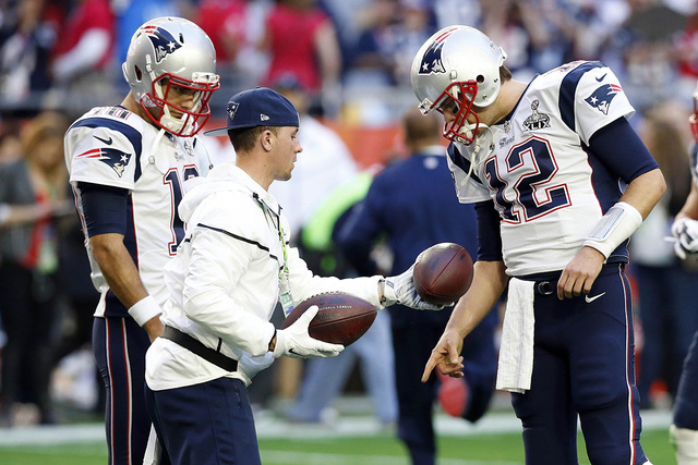 Feb 1, 2015; Glendale, AZ, USA; New England Patriots quarterback Tom Brady (12) looks at footballs before the game against the Seattle Seahawks in Super Bowl XLIX at University of Phoenix Stadium. ...