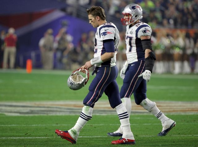 New England Patriots quarterback Tom Brady (12) walks to the sidelines with teammate Rob Gronkowski (87) after being intercepted by Seattle Seahawks middle linebacker Bobby Wagner (not pictured) i ...