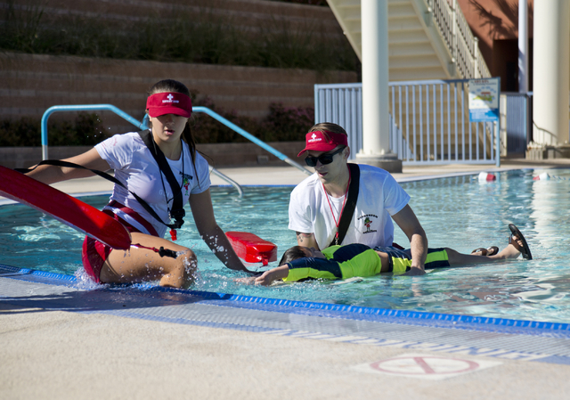 Christina Beaver, left, and Donavan Govenor participate in the mock rescue of Benjamin Hickman during the April Pools Day event at the Henderson Multigenerational Aquatic Complex in Henderson on T ...