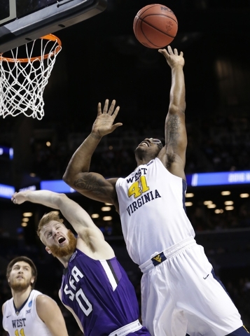 West Virginia's Devin Williams (41) and Stephen F. Austin's Thomas Walkup (0) fight for the ball during the first half of a first-round men's college basketball game in the NCAA Tournament,Friday, ...