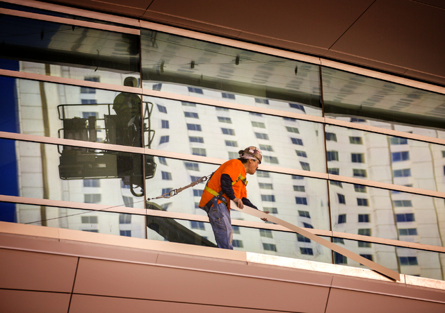 A worker places stripping on the T-Mobile Arena behind New York-New York on Monday, Feb. 29, 2016. The joint venture partners AEG and MGM Resorts is scheduled to open the arena next month. Jeff Sc ...