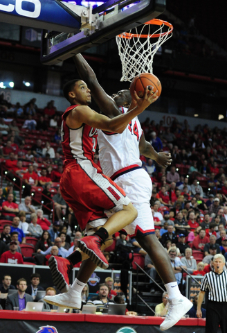 UNLV guard Jalen Poyser (24) goes up for a shot against Fresno State center Terrell Carter II (34) and forward Cullen Russo in the second half of their Mountain West Conference semifinal basketbal ...