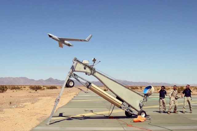 Marine Corps Sgt. Michael Kropiewnicki launches a Boeing ScanEagle drone during the 2006 training exercise Desert Talon at the Marine Corps Air Station Yuma, Ariz. Flight tests for a developmental ...