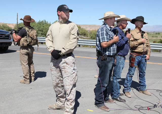 Armed guards surround Ammon Bundy, Cliven Bundy and Ryan Bundy as they do a remote interview with Sean Hannity of Fox News near Cliven Bundy's ranch in Bunkerville on Monday, April 14, 2014. (Just ...