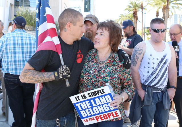 Brian Enright, left, hugs Carol Bundy, wife of Cliven Bundy, as she arrives to protest outside Lloyd George Federal Building on Thursday, March 10, 2016, in Las Vegas. Cliven Bundy appears in cour ...