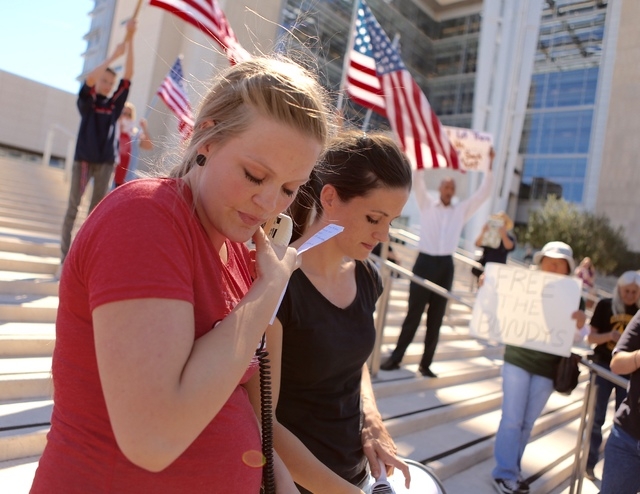 Brittney Beck, left, and Thara Tenney, daughters of Robert "La Voy" Finicum, sing a song they wrote during demonstration in front of Lloyd George Federal Building on Thursday, March 10, 2016, in L ...