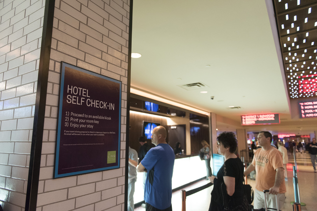 Signage for the seven new self check-in kiosks hangs on a column adjacent to the traditional check-in counter located in the lobby at The Linq Hotel in Las Vegas Wednesday, March 16, 2016. Jason O ...