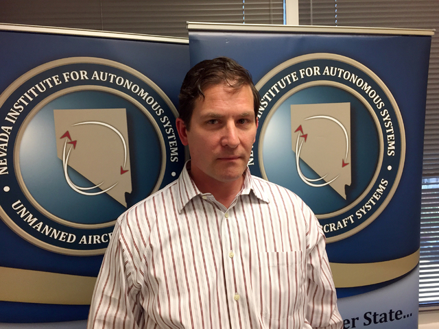 Chris Walach, of the Nevada Institute for Autonomous Systems, poses in front of posters for the state's drone test flight program during an interview at the institute's Las Vegas office March 14,  ...