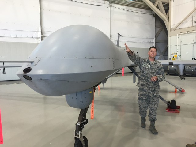 Capt. Will, a maintenance officer, pats the fuselage of an MQ-1B Predator aircraft inside a hangar June 16, 2015, at Creech Air Force Base. Certain personnel involved with remotely piloted aircraf ...
