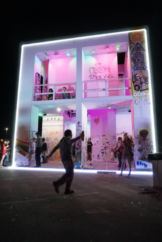 Life Cube artist Scott Cohen, center, dances as the LED lights are turned on during the illumination ceremony for the Life Cube in the Llama Lot at Fremont Street and 9th Street in Las Vegas Satur ...