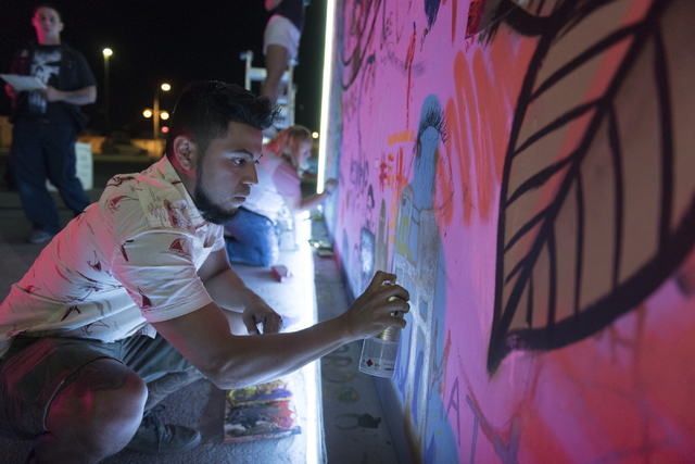 Herminio &quot;Herms&quot; Alvarez paints during the illumination ceremony for the Life Cube in the Llama Lot at Fremont Street and 9th Street in Las Vegas Saturday, March 19, 2016. The ce ...