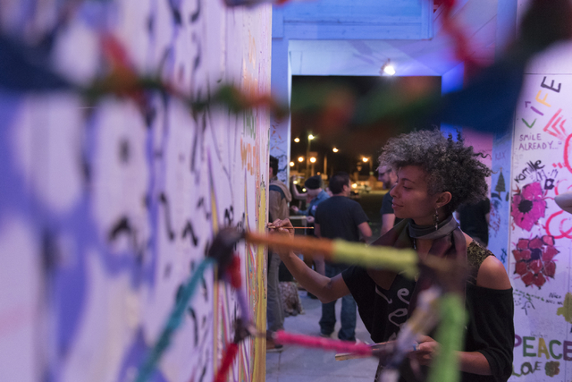 Brianna Coleman paints during the illumination ceremony for the Life Cube in the Llama Lot at Fremont Street and 9th Street in Las Vegas Saturday, March 19, 2016. The ceremony kicks off two weeks  ...