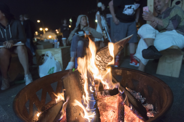 Friends hang around a bonfire during the illumination ceremony for the Life Cube in the Llama Lot at Fremont Street and 9th Street in Las Vegas Saturday, March 19, 2016. The ceremony kicks off two ...