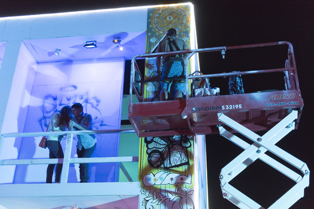 Jason Garuda, right, paints during the illumination ceremony for the Life Cube in the Llama Lot at Fremont Street and 9th Street in Las Vegas Saturday, March 19, 2016. The ceremony kicks off two w ...