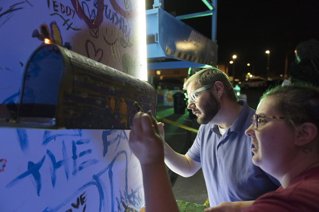 Lance Wilson, left, and Jami Velez paint during the illumination ceremony for the Life Cube in the Llama Lot at Fremont Street and 9th Street in Las Vegas Saturday, March 19, 2016. The ceremony ki ...