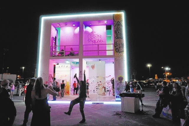 Life Cube artist Scott Cohen, center, dances as the LED lights are turned on during the illumination ceremony for the Life Cube in the Llama Lot at Fremont Street and 9th Street in Las Vegas Satur ...