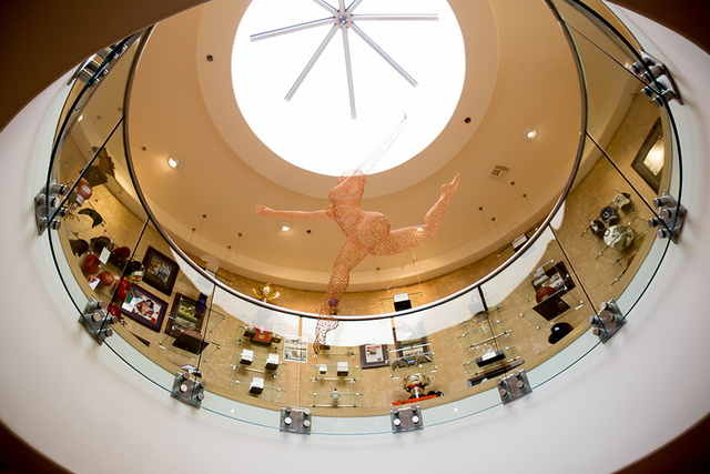 Hanging above a circular, two-story office is a fiber-optic cable sculpture of a ballerina that moves. The office’s second floor is a sport memorabilia museum. (TONYA HARVEY/REAL ESTATE MILLIONS)