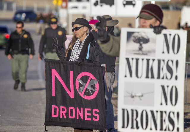 Anti-drone protestor Martha Hurbert,center, flashes a peace sign at the south entrance of  Creech Air Force Base in Indian Springs on Friday, March 6, 2015. Thirty-four protestors were cited for p ...