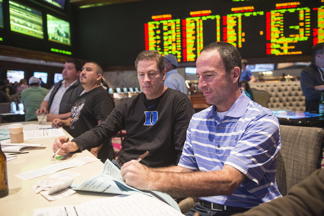 Chuck Andolina, left, and Jeff Reynolds from Dallas place bets on the Super Bowl at the sports book in the Mirage in Las Vegas on Saturday, Jan. 31, 2015. Andolina and Reynolds have traveled to La ...