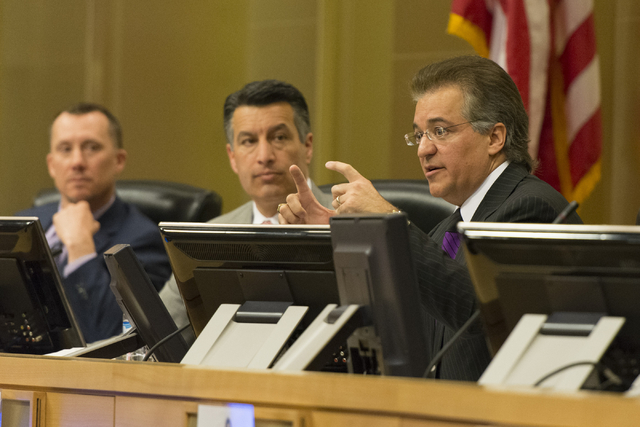 A.G. Burnett, chairman of the Nevada Gaming Control Board, left, and Nevada Governor Brian Sandoval, center, listen as Tony Alamo, chairman of the Nevada Gaming Control Board are seen at the Nevad ...