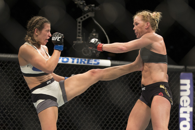 Miesha Tate, left, connects a kick against Holly Holm in their women’s bantamweight title bout during UFC 196 at MGM Grand Garden ArenaSaturday, March 5, 2016, in Las Vegas. Tate won by way ...