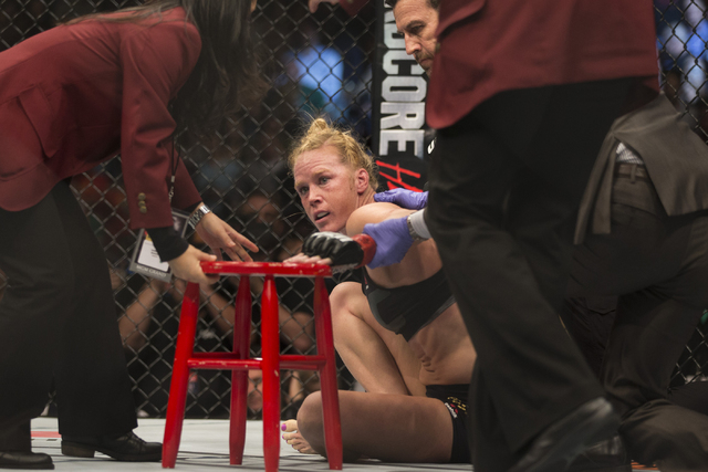 Holly Holm is assisted off the octagon after her loss by way of submission against Miesha Tate in their women’s bantamweight title bout during UFC 196 at MGM Grand Garden ArenaSaturday, Mar ...