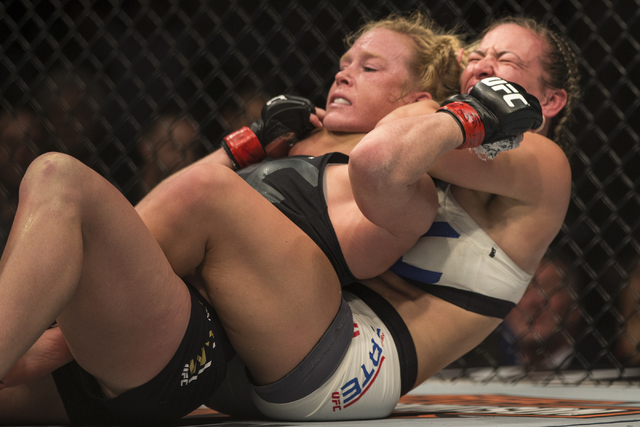 Miesha Tate applies a rear-naked choke to submit Holly Holm in the fifth round and take her bantamweight championship at UFC 196 at the MGM Grand Garden on March 5, 2016, in Las Vegas. Erik Verduz ...