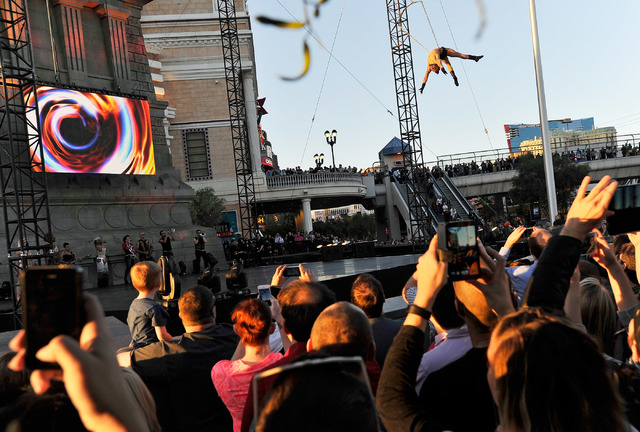 Tourists watch a Cirque du Soleil preview performance in front of the New York New York hotel-casino in Las Vegas on Thursday, Feb. 26, 2015. (David Becker/Las Vegas Review-Journal)
