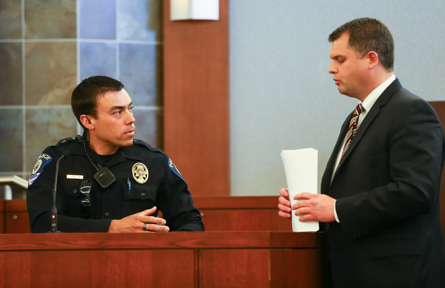 Prosecutor Jason Margolis, right, shows photos to Clark County School District police officer Steven Patty during the trial of Jason Lofthouse at the Regional Justice Center in Las Vegas on Tuesda ...