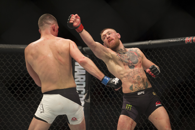 Conor McGregor, right, throws a punch against Nate Diaz in the menճ welterweight bout during UFC 196 at MGM Grand Garden ArenaSaturday, March 5, 2016, in Las Vegas. Diaz won way of submissio ...