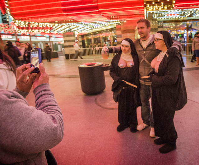 A man poises with buskers at Fremont Street Experience. (Jeff Scheid/Las Vegas Review-Journal)