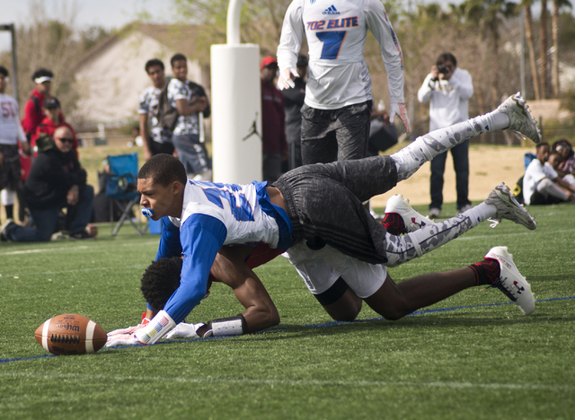 702 Elite's Greg Oliver (13), top, breaks up a pass intended for a Texas Elite player during the Pylon Elite 7v7 Las Vegas National football tournament at All American Park in Las Vegas on Saturda ...