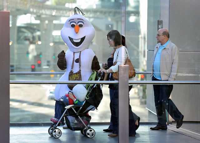 Tourists encounter a character looking for tips as they walk along a pedestrian bridge at Harmon Boulevard and the Strip in Las Vegas on Thursday, Feb. 26, 2015. David Becker/Las Vegas Review-Journal