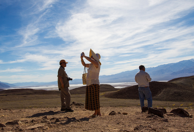 Bailing Zhang of Palos Verdes, Calif., center, takes a photo as Herman Pang, left, and Felix Pang look on during a stop along Artists Drive in Death Valley National Park, Calif. on Saturday, Feb.  ...