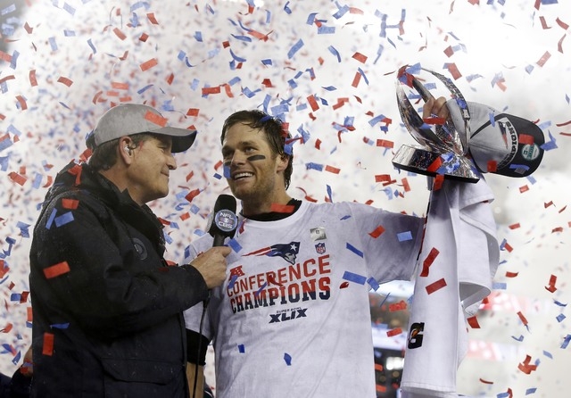 Jan 18, 2015; Foxborough, MA, USA; New England Patriots quarterback Tom Brady (right) holds up the Lamar Hunt Trophy as he is interviewed after the AFC Championship Game against the Indianapolis C ...