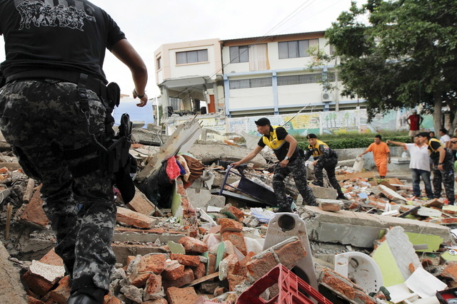 Red Cross members, military and police officers work at a collapsed area after an earthquake struck off Ecuador's Pacific coast, at Tarqui neighborhood in Manta April 17, 2016. (Guillermo Granja/R ...