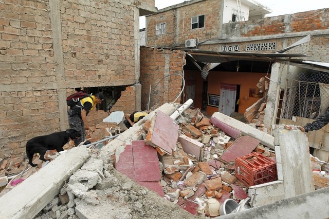 Police officers search through debris after an earthquake struck off Ecuador's Pacific coast, at Tarqui neighborhood in Manta April 17, 2016.  (Guillermo Granja/Reuters)
