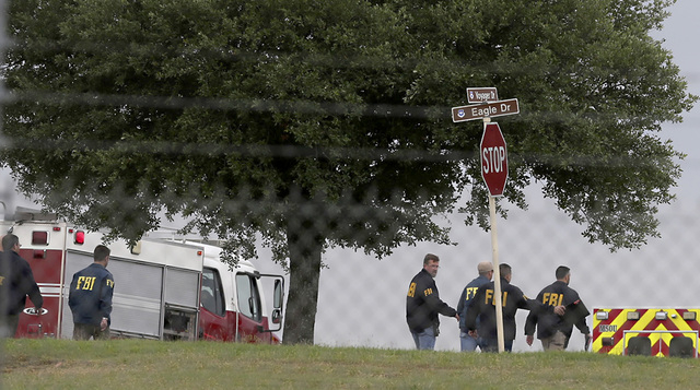 First responders and FBI agents gather near the scene of a shooting at Joint Base San Antonio-Lackland, Friday, April 8, 2016, in Texas. (John Davenport/The San Antonio Express-News via AP)