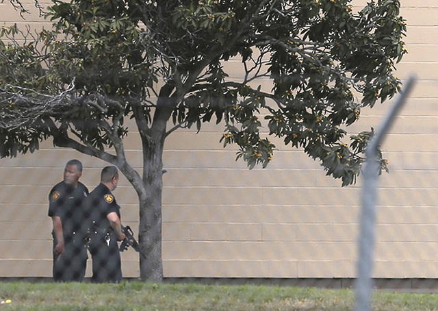 Two Bexar County Sheriff's Deputies stand outside a building near the scene of a shooting at Joint Base San Antonio-Lackland, Friday, April 8, 2016, in Texas. (John Davenport/The San Antonio Expre ...